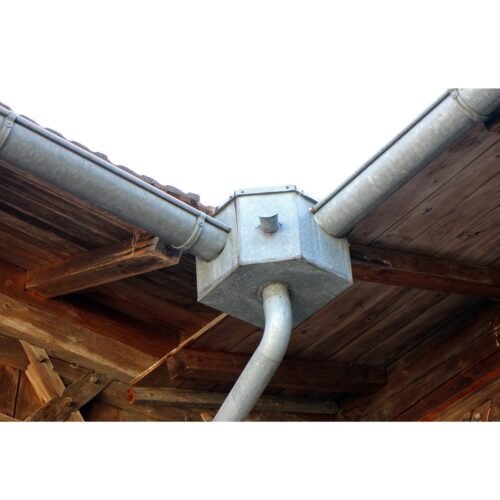 A metal pipe resting on a roof.