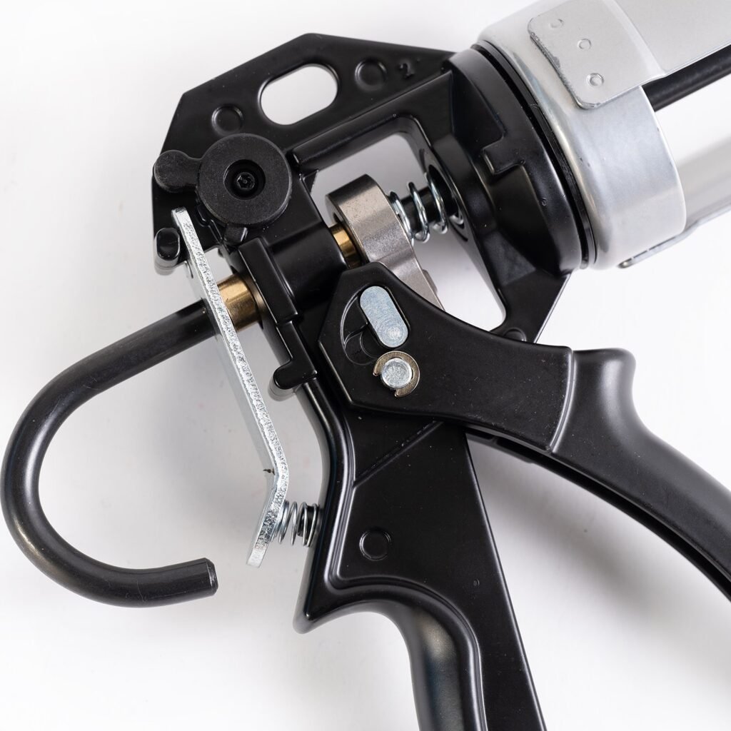 A black and silver gun resting on a flat surface, surrounded by metalware items.